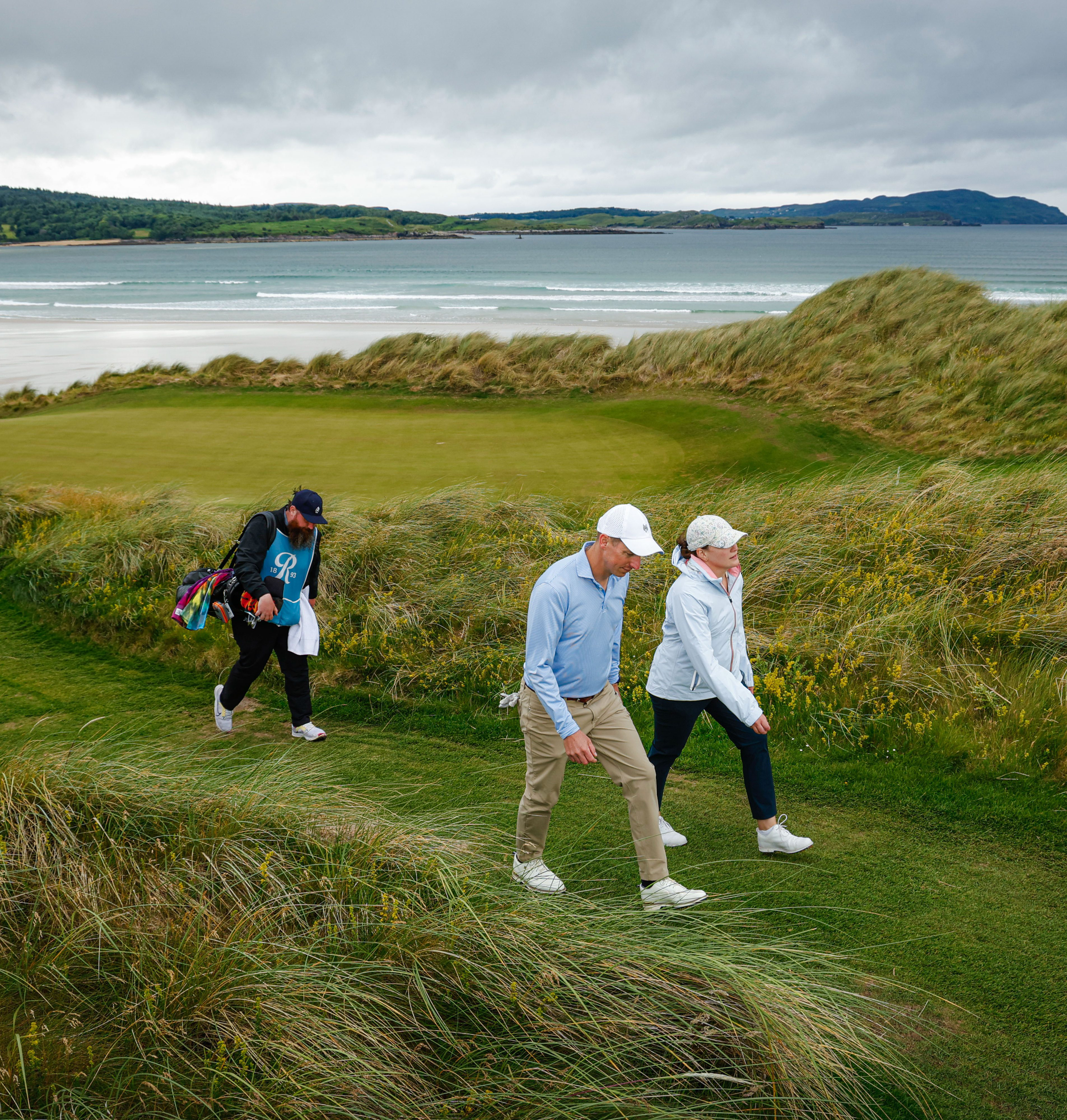 Caddie walking with golfers